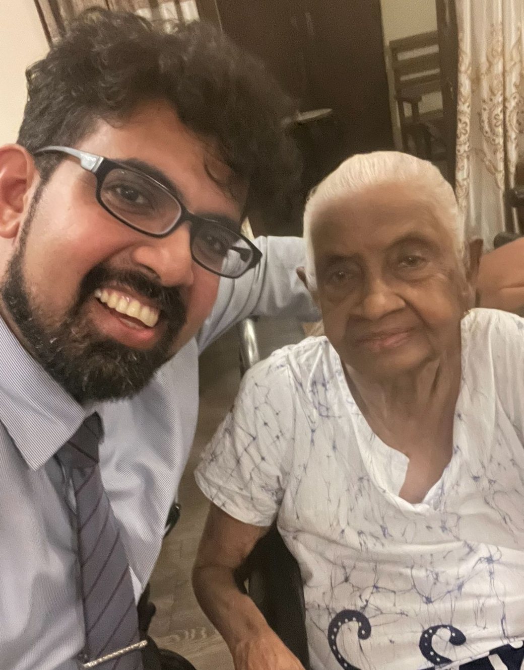 Dr Sithira Senevirathne beside an elderly patient at her home in Colombo, both smiling at the camera